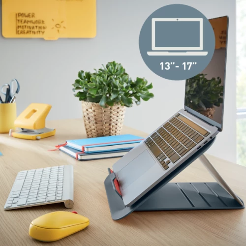 szara podstawka z laptopem, postawiona na biurku z myszką i klawiaturą